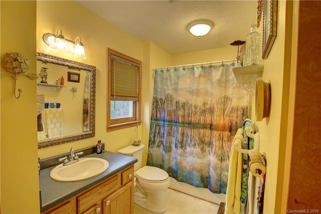 951 Price Town Road Clyde, NC 28721 - Photo 14 of 36 a bathroom with a granite countertop sink toilet and shower
