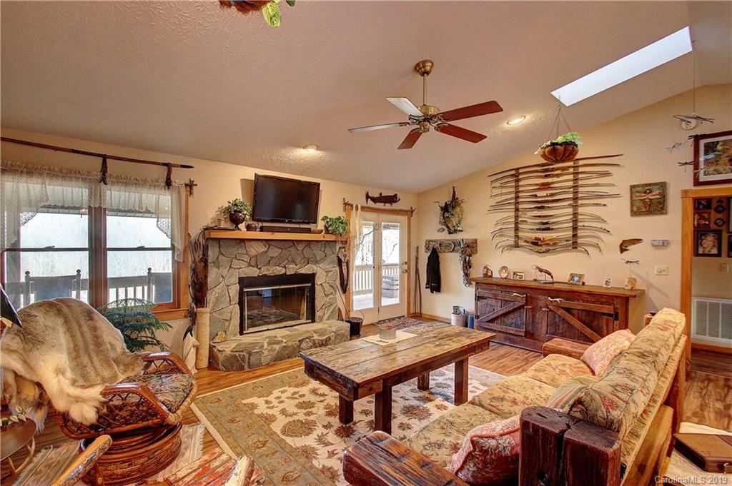 951 Price Town Road Clyde, NC 28721 - Photo 3 of 36 a living room with furniture a flat screen tv and a fireplace