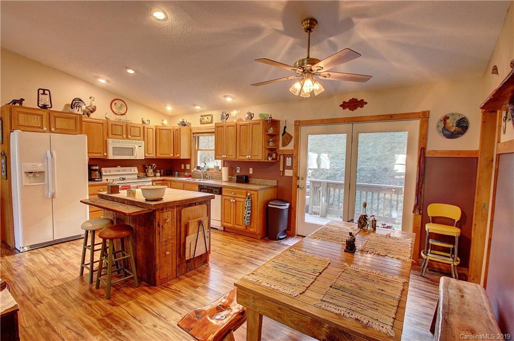 951 Price Town Road Clyde, NC 28721 - Photo 8 of 36 a open kitchen with stainless steel appliances granite countertop a stove refrigerator and wooden floor