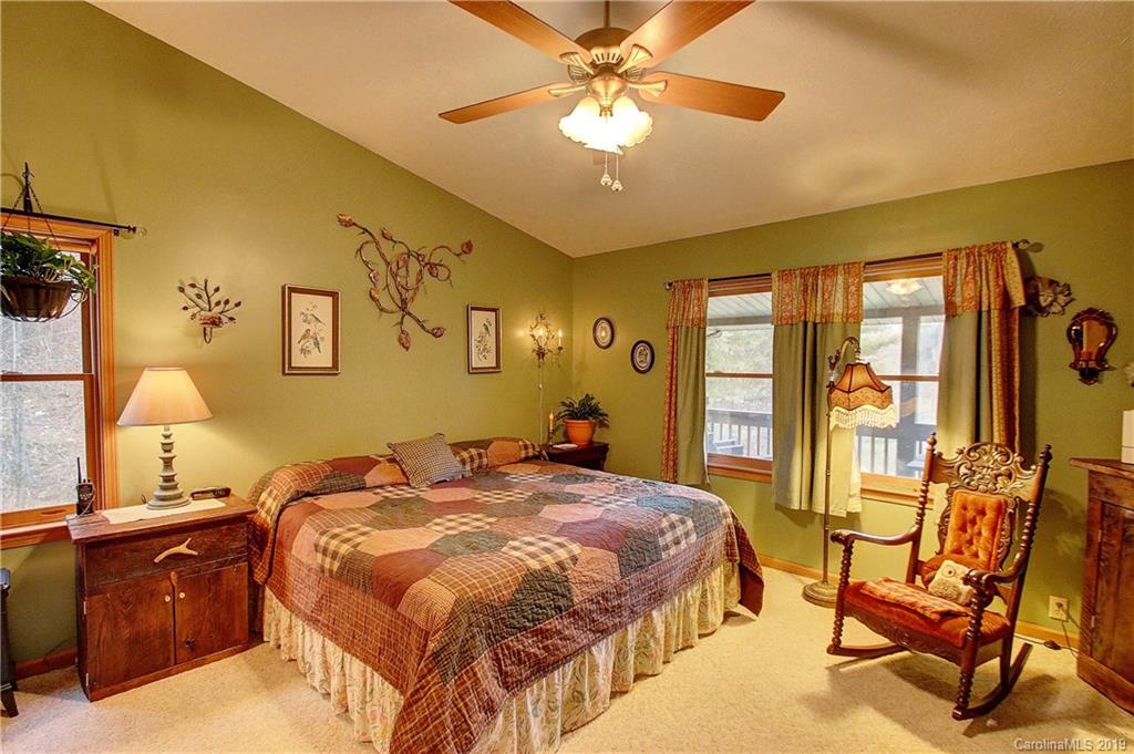 951 Price Town Road Clyde, NC 28721 - Photo 9 of 36 a bedroom with a bed and a chandelier