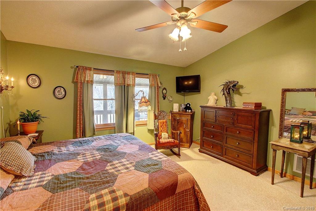 951 Price Town Road Clyde, NC 28721 - Photo 10 of 36 a bedroom with a bed and a chandelier