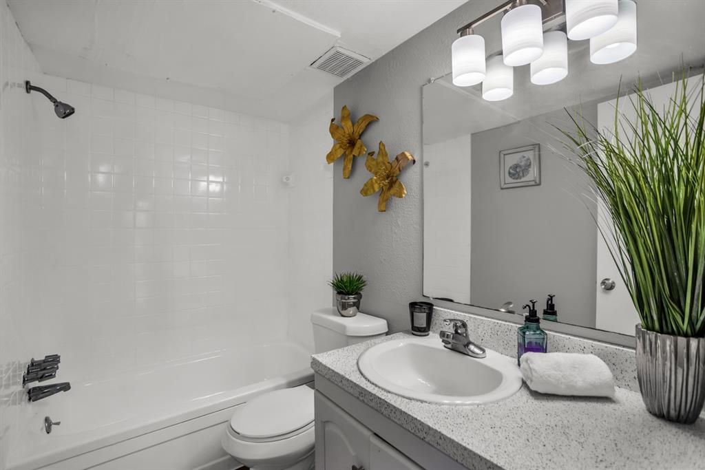 13769 Brookgreen Circle Dallas, TX 75240 - Photo 17 of 18 a bathroom with a granite countertop sink a toilet and a mirror