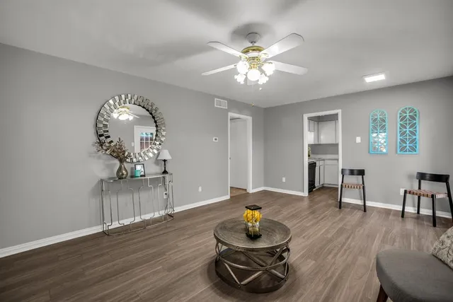 a living room with furniture and wooden floor