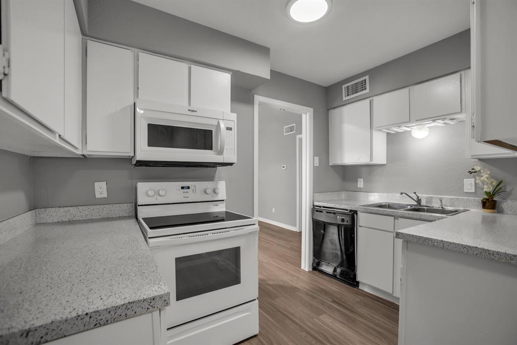 13769 Brookgreen Circle Dallas, TX 75240 - Photo 10 of 18 a kitchen with cabinets stainless steel appliances and wooden floor