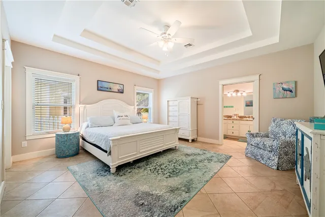 a spacious bedroom with a bed and a chandelier