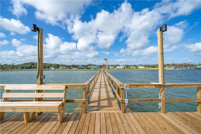 a view of a swimming pool with a bench and trees in the background