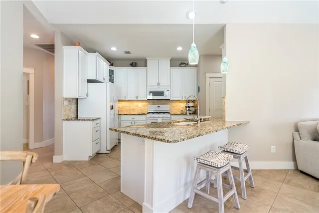 a kitchen with stainless steel appliances granite countertop a sink and a stove