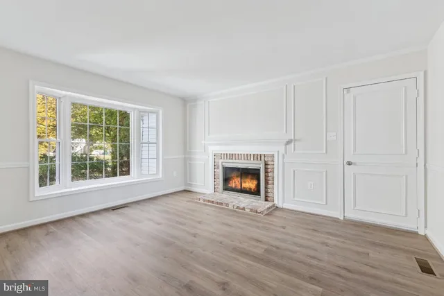 a view of an empty room with a fireplace and a window
