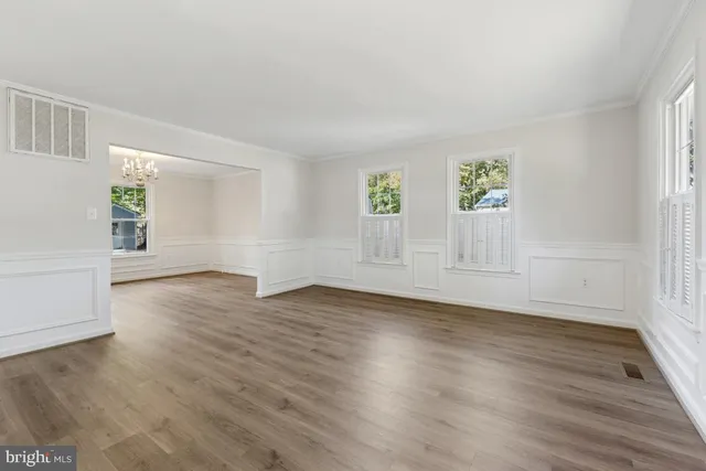 an empty room with wooden floor and window