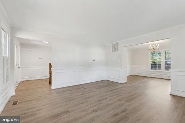 a view of empty room with wooden floor and window