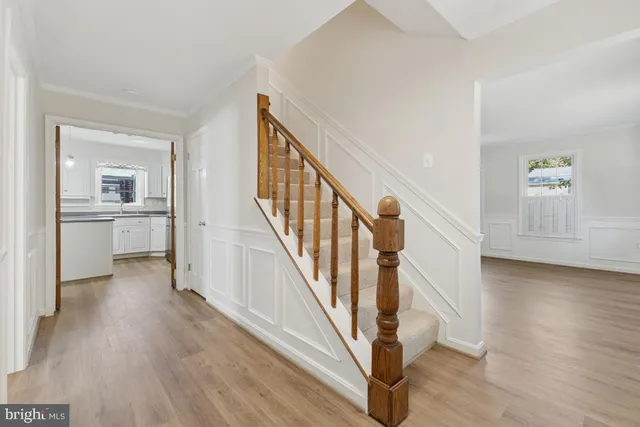 a view of a hallway with wooden floor and entryway