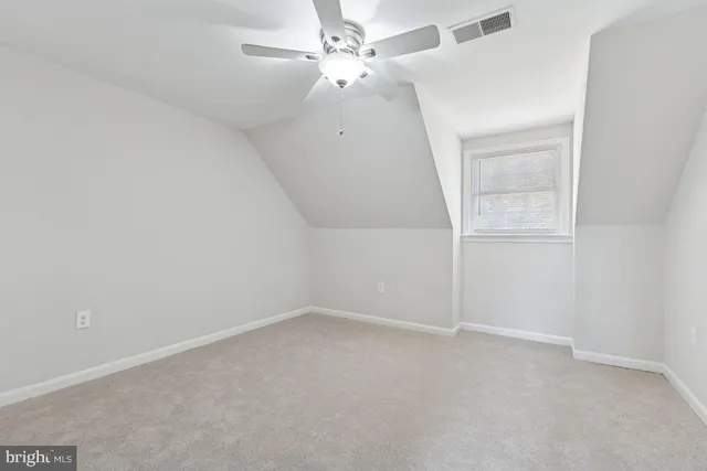 an empty room with a window and ceiling fan