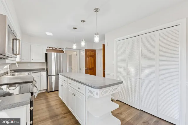 a large white kitchen with a sink and refrigerator