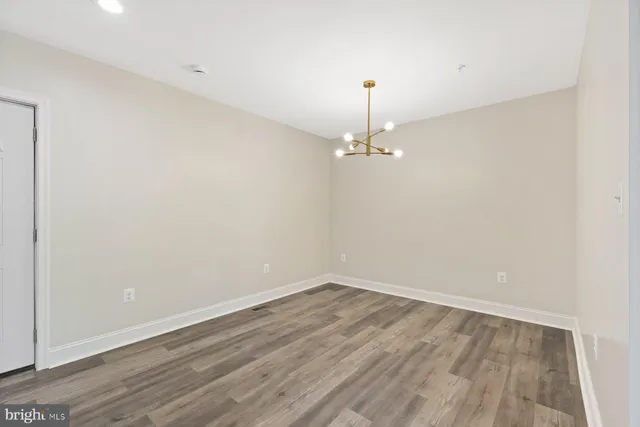 a view of a room with wooden floor and chandelier