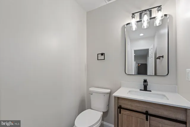 a bathroom with a toilet a sink and mirror