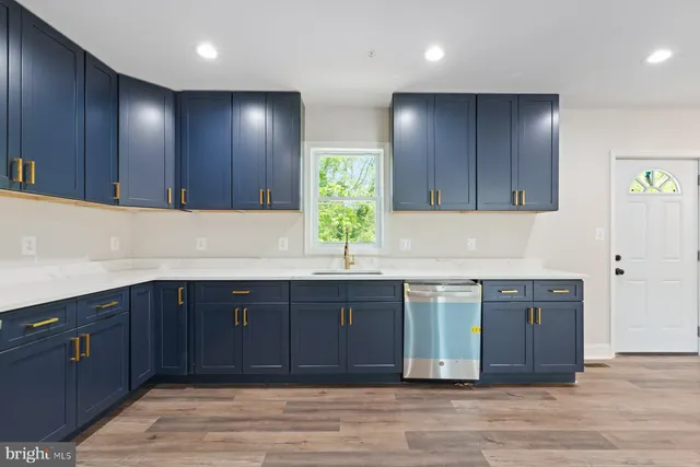 a kitchen with stainless steel appliances granite countertop wooden cabinets and a sink