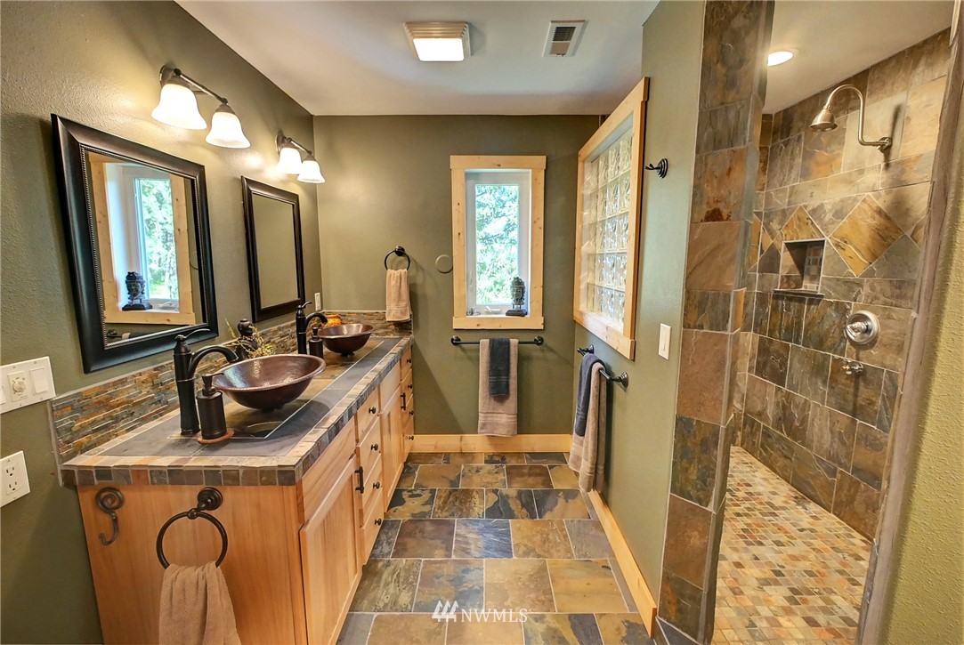 41 Trillium Road Winthrop, WA 98862 - Photo 22 of 39 a bathroom with a sink a mirror a vanity and a shower
