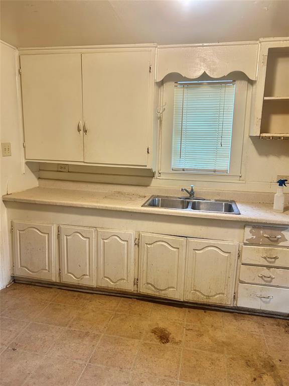 1016 North Howeth Street Gainesville, TX 76240 - Photo 4 of 15 a bathroom with a sink and a mirror