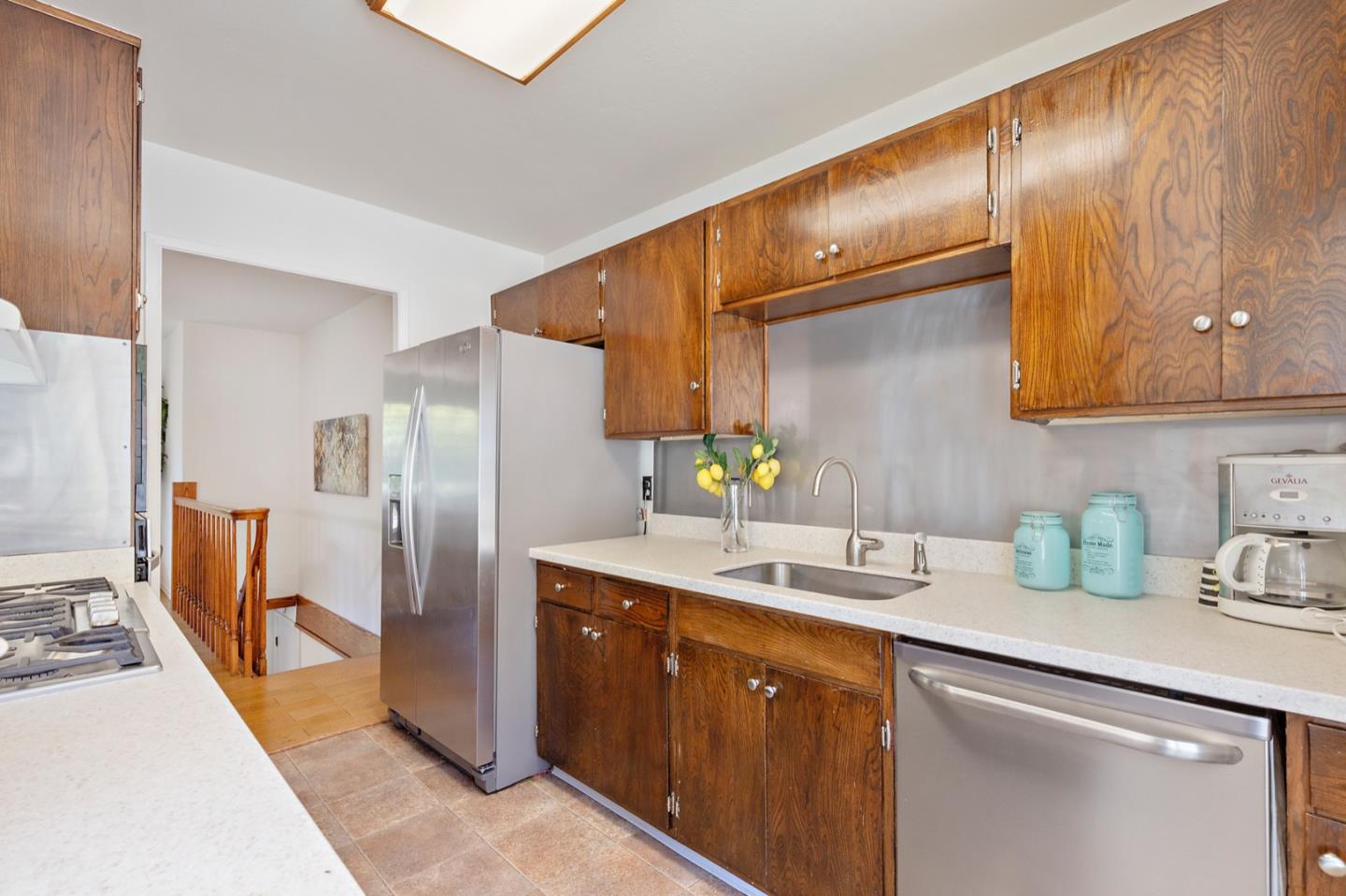 1528 Terra Nova Boulevard Pacifica, CA 94044 - Photo 15 of 32 a kitchen with stainless steel appliances a sink a refrigerator and cabinets