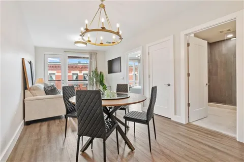 a dining room with furniture a chandelier and wooden floor