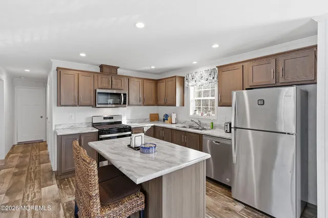 a kitchen with a refrigerator a stove a sink cabinets and a refrigerator