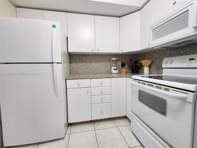 a kitchen with white cabinets and white appliances