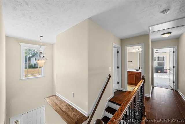 a view of a hallway with furniture and wooden floor