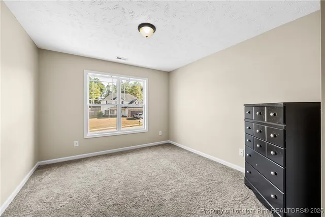an empty room with windows and cabinet