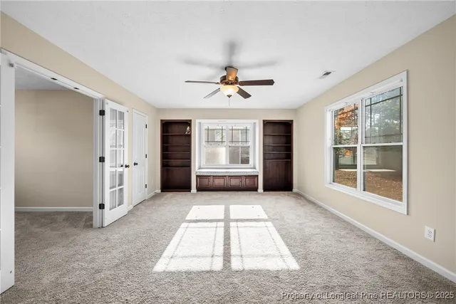 an empty room with windows and cabinet