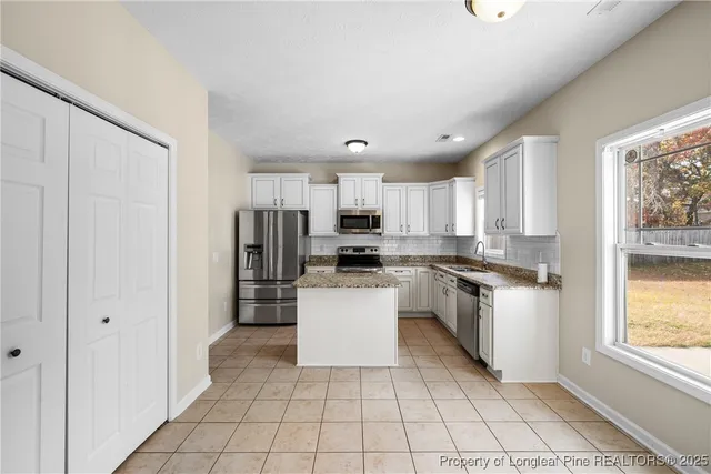 a kitchen with a refrigerator a sink and a stove top oven