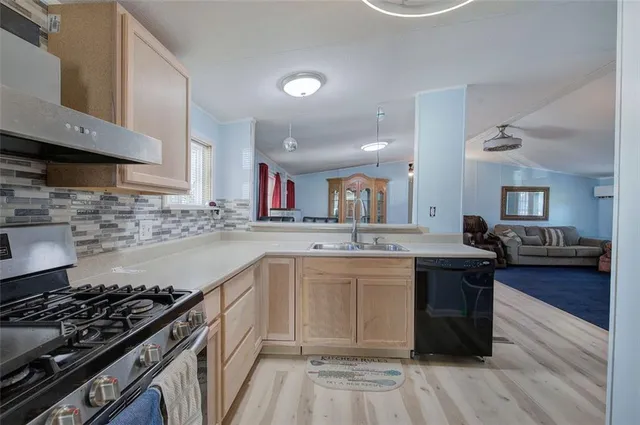 a kitchen with a sink stove and wooden floor