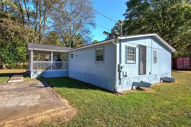 a view of a house with backyard and trees