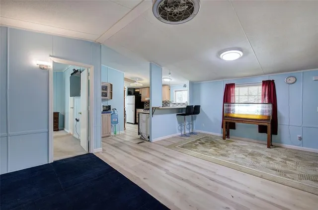 a view of a kitchen with refrigerator stove and wooden floor