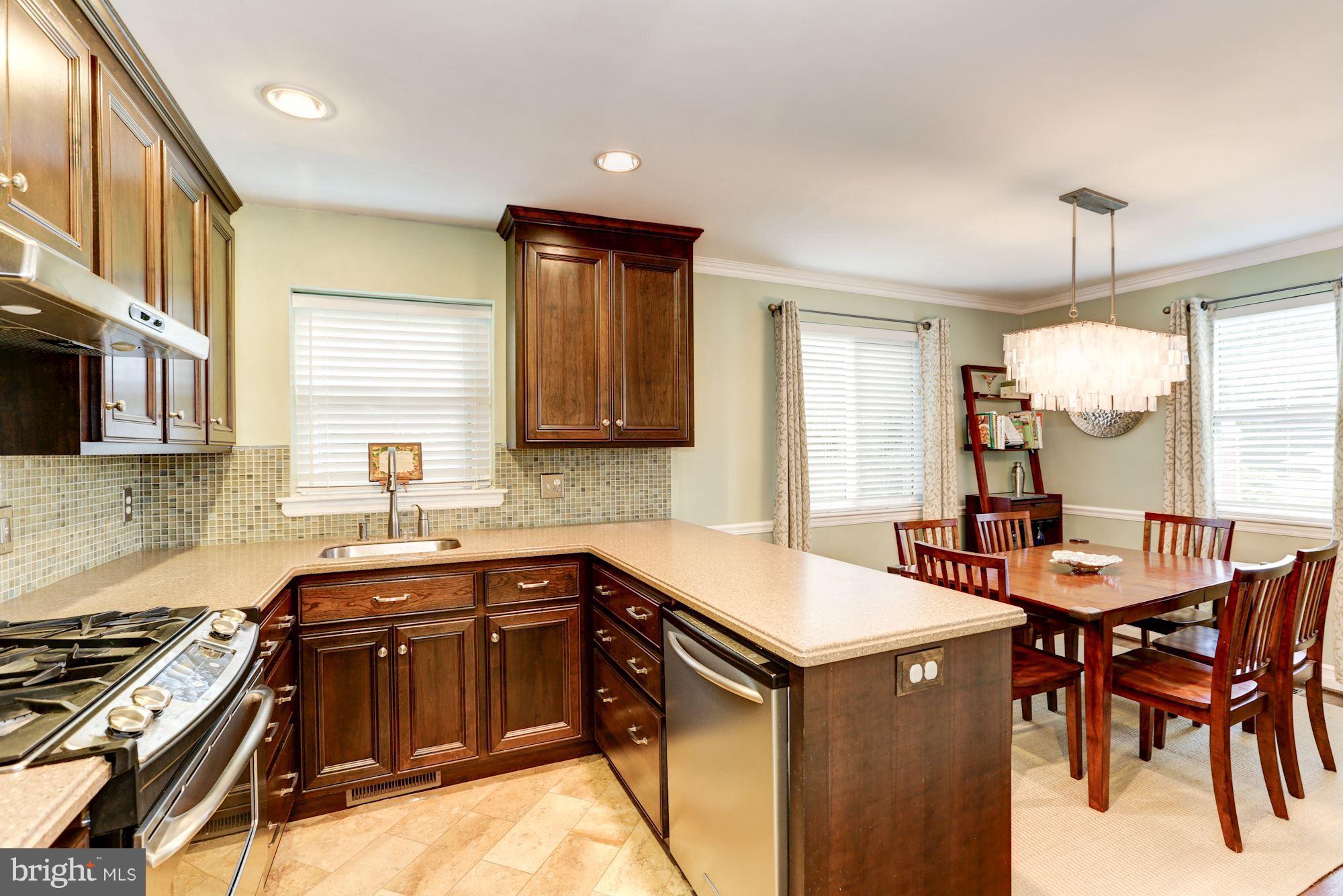 10016 Sidney Road Silver Spring, MD 20901 - Photo 4 of 25 a kitchen that has a sink a stove and chairs in it