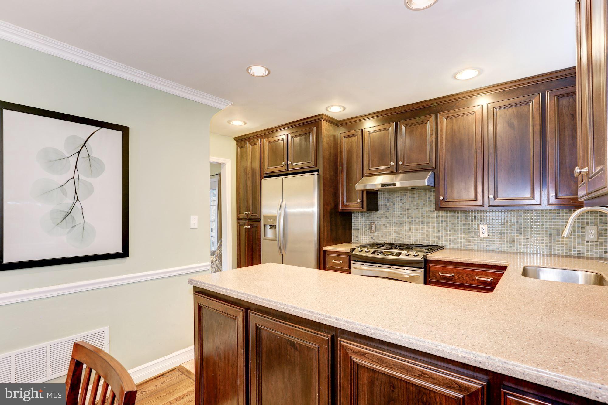 10016 Sidney Road Silver Spring, MD 20901 - Photo 5 of 25 a kitchen with stainless steel appliances a refrigerator and cabinets