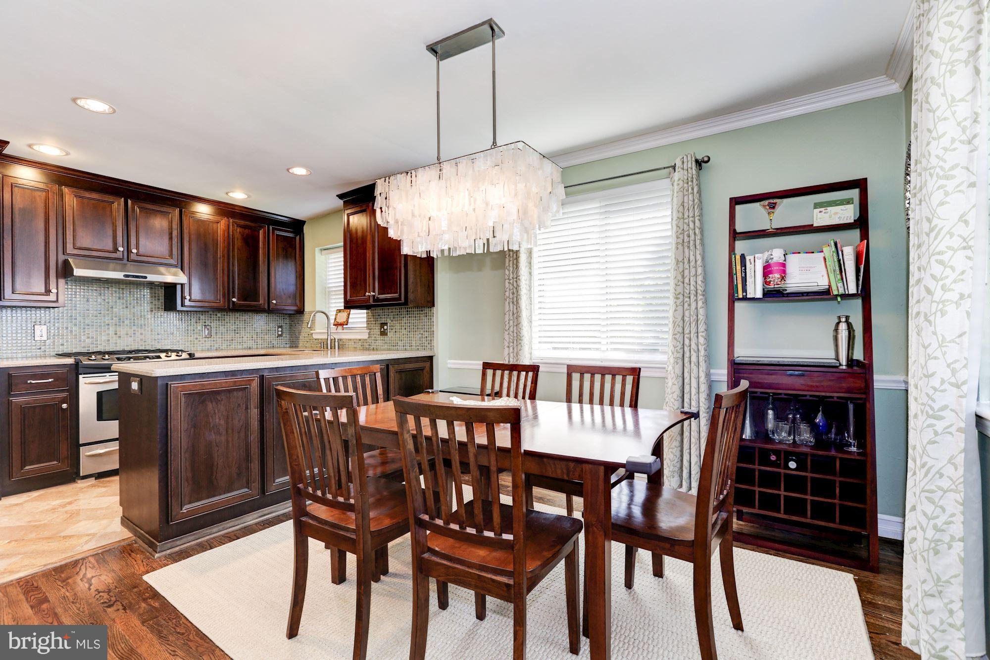 10016 Sidney Road Silver Spring, MD 20901 - Photo 7 of 25 a dining room with stainless steel appliances kitchen island granite countertop a dining table chairs and a oven