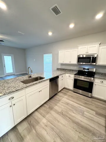 a large kitchen with granite countertop a stove top oven a sink and dishwasher a oven with granite countertops