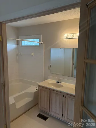 a bathroom with a tub sink and mirror