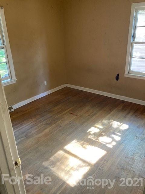 302 Lydia Street Monroe, NC 28110 - Photo 11 of 14 an empty room with wooden floor and windows