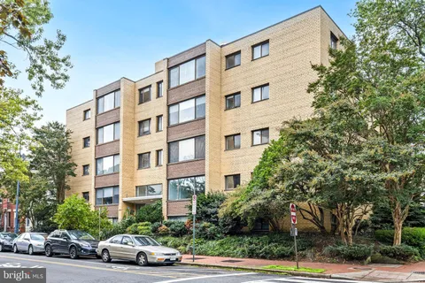 a car parked in front of a building and a cars parked on road