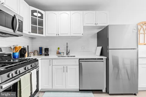 a kitchen with stainless steel appliances granite countertop a refrigerator and a stove