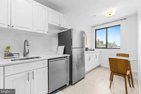 a kitchen with stainless steel appliances white cabinets and a refrigerator