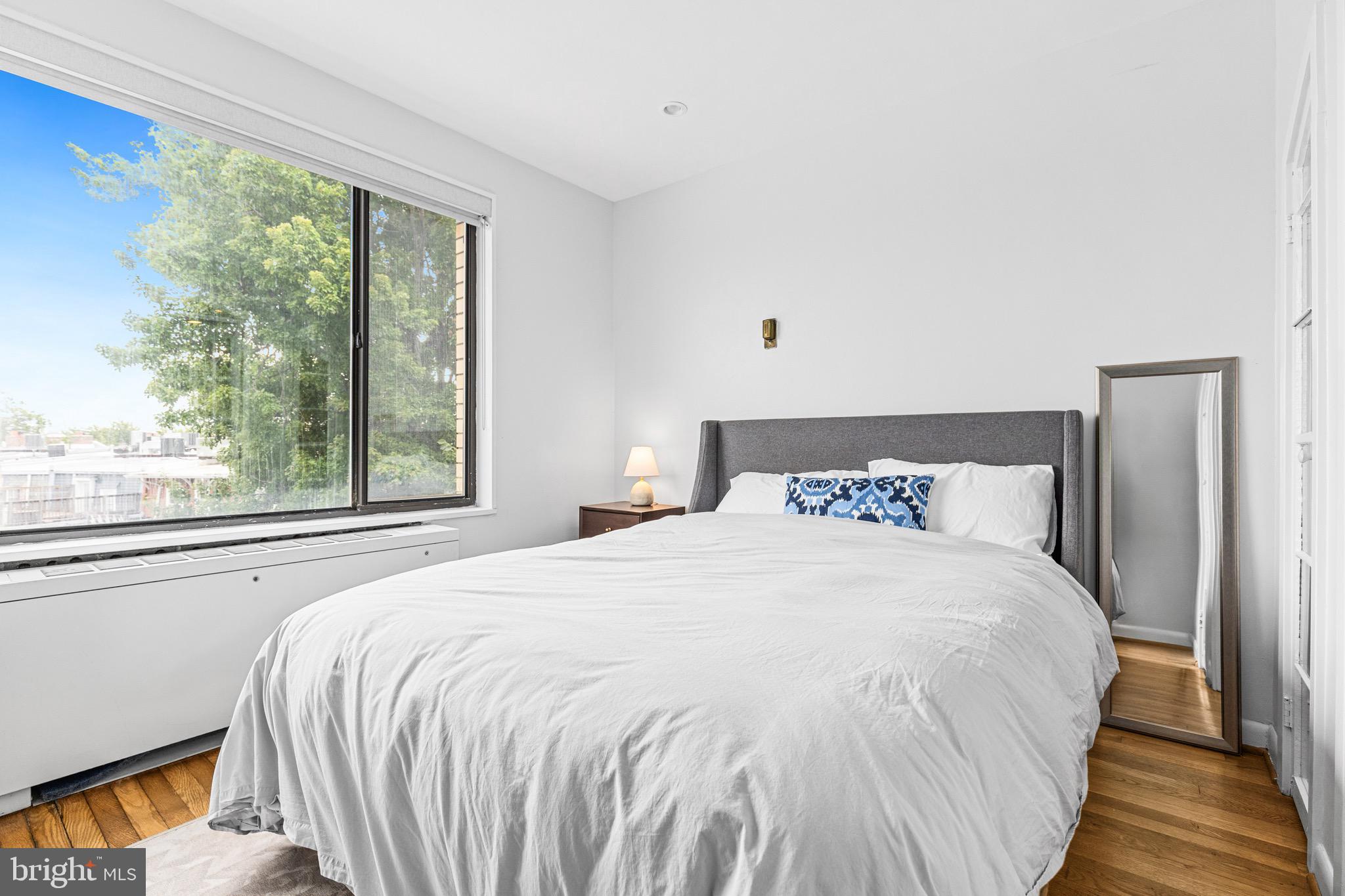 305 C Street Northeast, Unit 410 Washington, DC 20002 - Photo 9 of 15 a large bed sitting in a bedroom next to a window