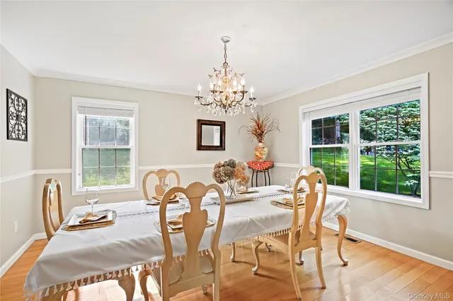 a view of a dining room with furniture a chandelier and wooden floor
