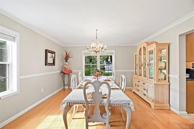 a dining room with furniture a chandelier and wooden floor