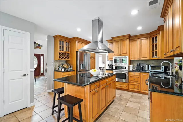 a kitchen with stainless steel appliances granite countertop a sink a stove and refrigerator