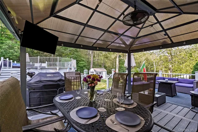 a view of a roof deck with table and chairs and wooden floor