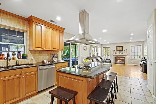a kitchen with stainless steel appliances granite countertop sink stove and white cabinets with wooden floor
