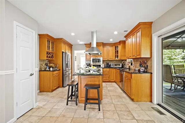 a kitchen with stainless steel appliances granite countertop a refrigerator and a stove top oven
