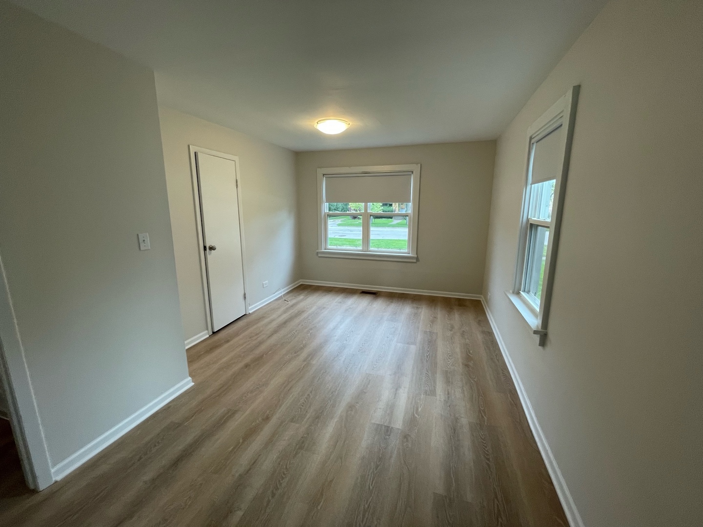 977 Spring Road Elmhurst, IL 60126 - Photo 6 of 13 an empty room with wooden floor and windows
